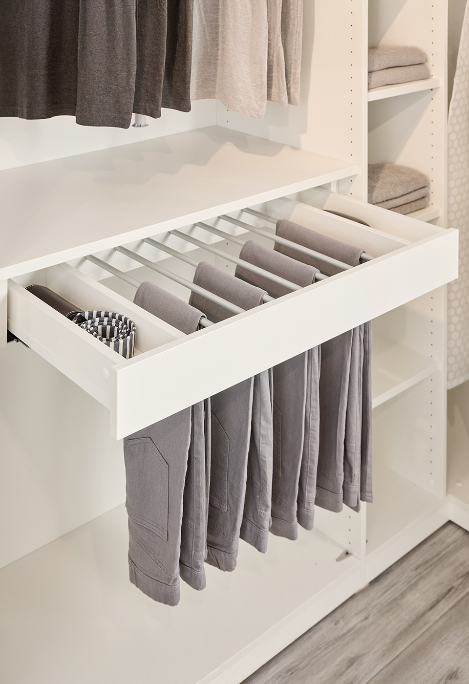 Ein Hosenauszug mit 7 Möglichkeiten Hosen aufzuhängen und links und rechts ein Ablagefach für die kleinen Dinge