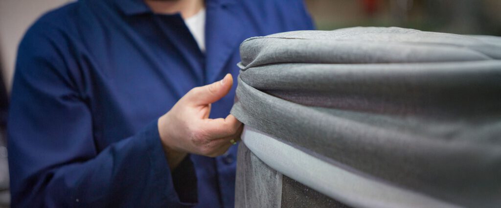 Stoff wird auf ein Möbelstück bezogen - Herobild für das Thema Textilkennzeichnung
