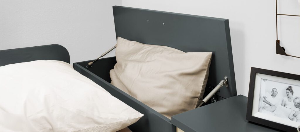 geöffnete Bettzeugtruhe hinter Kopfteil vom Bett